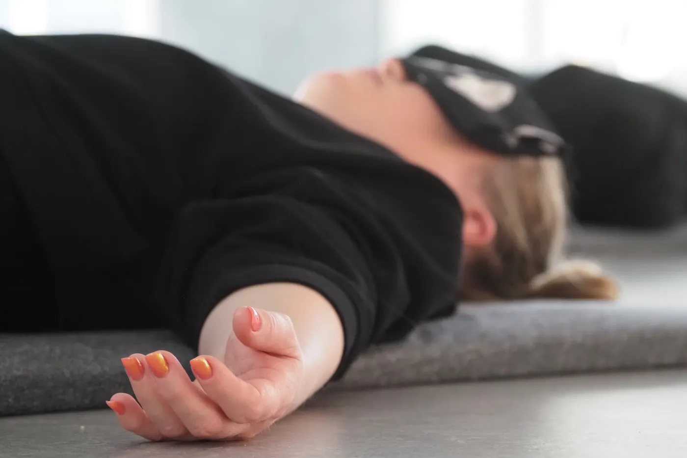 Deltager ligger helt stille med øjenpude under yoga nidra